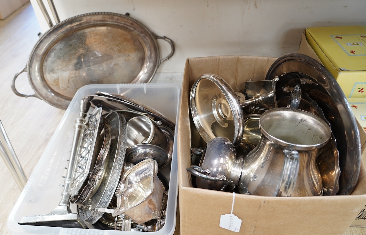 Two boxes of plated ware including a tall candlestick, a two handled tray and two galleried trays. Condition - fair